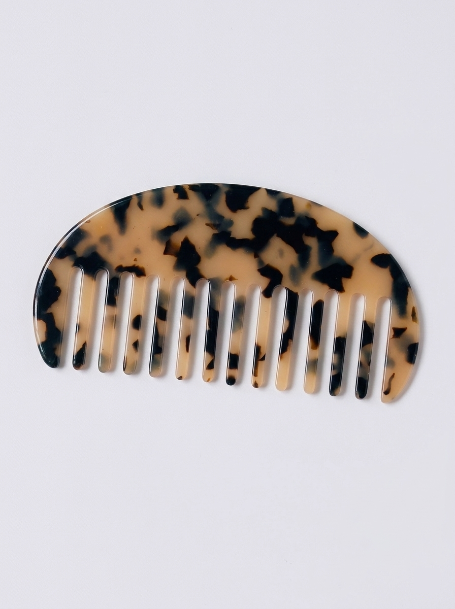 Half moon acetate hair comb on surface - alternate view