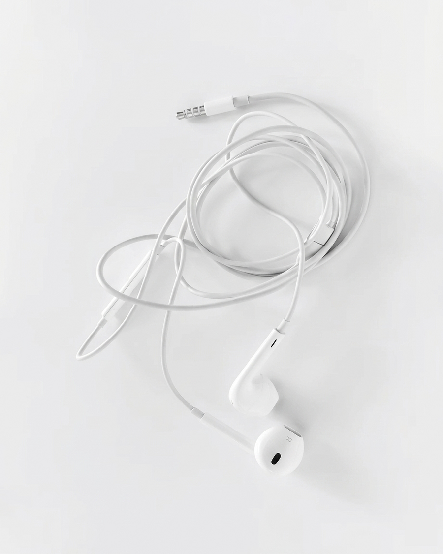 Classic white wired earbuds on white background